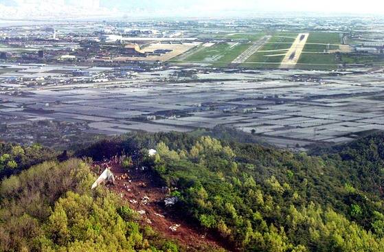 2002년 당시 하늘에서 내려다 본 경남 김해 돗대산 중국 여객기 추락사고 현장．산 너머로 김해 공항의 활주로가 보인다. 중앙포토
