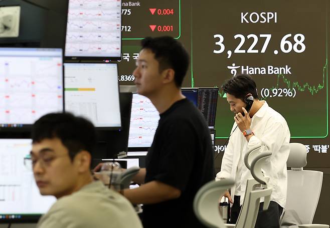 코스피가 29.54p(0.92%) 오른 3227.68에 장을 종료한 지난 7일 서울 하나은행 본점 딜링룸에서 딜러들이 업무를 보고 있다. [연합]