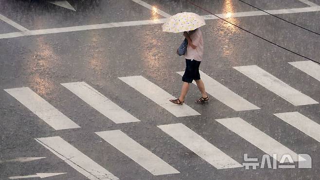 [서울=뉴시스] 홍효식 기자 = 소나기가 내린 8일 서울 중구 을지로1가 사거리에서 한 시민이 우산을 쓰고 발걸음을 재촉하고 있다. 2025.08.08. yesphoto@newsis.com