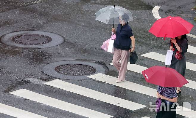 [서울=뉴시스] 홍효식 기자 = 소나기가 내린 8일 서울 중구 을지로1가 사거리에서 시민들이 우산을 쓰고 발걸음을 재촉하고 있다. 2025.08.08. yesphoto@newsis.com