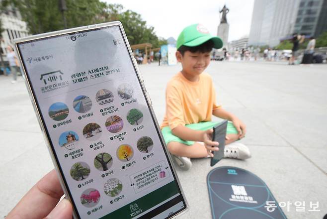 서울시가 지난 2024년 4월 도입한 ‘광화문 AI해설사’ 서비스 홍보를 위해 여름방학을 맞은 학생들을 대상으로 AI해설사 스탬프 투어 챌린지를 진행하고 있다. 핸드폰으로 QR 코드를 촬영하면 포인트별로 해설을 들을 수 있고 8개 이상 스탬프를 모으면 선물을 받는다.  한 학생이 챌린지에 도전하고 있다. 2024년 7월 30일 변영욱 기자. 동아일보 DB