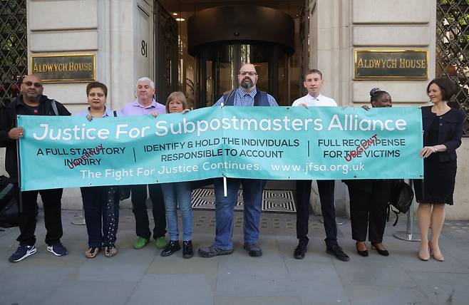 2024년 5월24일 영국 런던의 ‘우정국 사건’ 조사관 앞에서 전직 우체국 지점장들이 현수막을 들고 있다. ⓒEPA