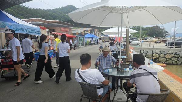 김두진(가운데) 용초마을 이장이 방문객들에게 섬에 대해 이야기하고 있다. /정봉화 기자