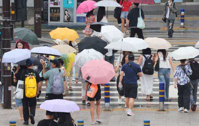 연일 이어진 비에 낮 최고기온이 30도 아래로 떨어진 10일 부산 동구 초량동 부산역 앞 횡단보도에 시민들이 우산을 받쳐들고 지나가고 있다. 정종회 기자 jjh@