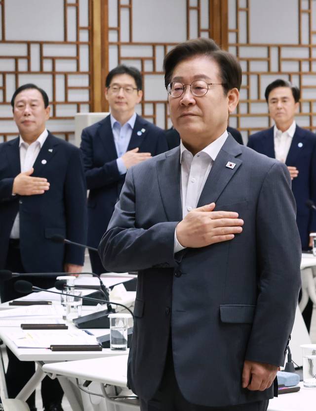 이재명 대통령이 지난 1일 서울 용산 대통령실 청사에서 열린 전국 시도지사 간담회에서 국기에 경례하고 있다. [연합뉴스]