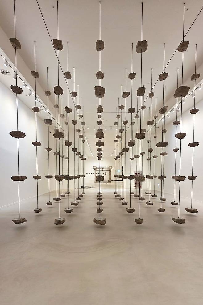 [사진=박현주 미술전문기자] 포도뮤지엄 '우리 이토록 작은 존재들' 전시 전경. 1전시실 입구에서 마주하는 모나 하툼(Mona Hatoum)의 작품,1.6톤짜리 콘크리트 덩어리와 철근이 공중에 매달린 모나 하툼의 작품은 평온해 보이면서도 위태로운 압도감으로 다가온다. 레바논의 팔레스타인 난민 가정에서 태어나 1975년 발발한 레바논 내전으로 고국에 돌아갈 수 없게 된 작가가 보여주는 붕괴 직전의 구조물은 묵직한 메시지를 던진다. *재판매 및 DB 금지