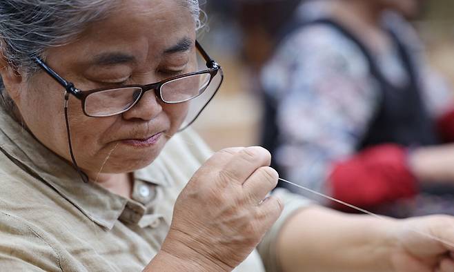 임능부(74)씨가 ‘삼 삼기’를 시연하며 침을 바르고 있다.