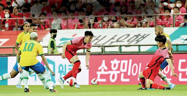 한국 축구국가대표 손흥민(가운데)이 2022년 6월 서울월드컵경기장에서 열린 브라질 축구국가대표와의 평가전에서 드리블하고 있다. 권도현 기자