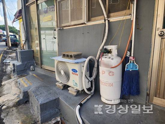 ▲ 울산 중구 복산동의 한 상가 앞. 에어컨 실외기 바로 옆에 LPG통이 놓여 있다. LPG통에는 금속배관 대신 낡은 고무호스가 연결돼있어 가스 누출 등 사고가 우려된다.