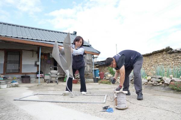 청송군 8282민원 처리팀이 주택의 방충망을 교체하고 있다.