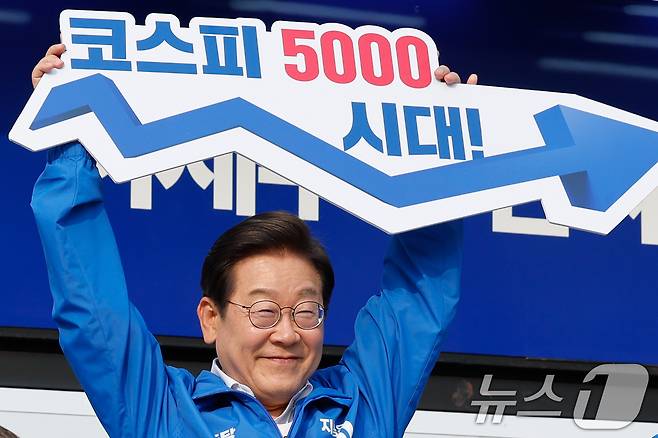 이재명 더불어민주당 대통령 후보가 제21대 대통령선거 사전투표 첫날인 29일 오후 서울 서초구 고속버스터미널광장에서 '코스피 5000시대'라고 적힌 피켓을 들고 있다. 2025.5.29/뉴스1 ⓒ News1 안은나 기자