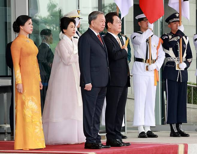 이재명 대통령과 김혜경 여사가 11일 서울 용산 대통령실 청사 앞에서 열린 또 럼 베트남 당서기장 공식환영식에서 국기에 경례를 하고 있다. 뉴시스