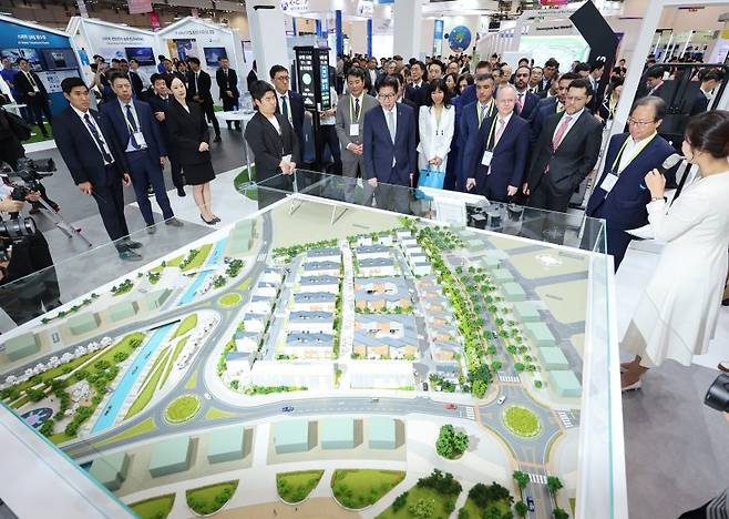지난 7월 부산 해운대구 벡스코 제1전시장에서 열린 '2025 월드 스마트시티 엑스포'에서 참석 내빈들이 에코델타시티의 스마트시티 모형을 살펴 보고 있다. 연합뉴스