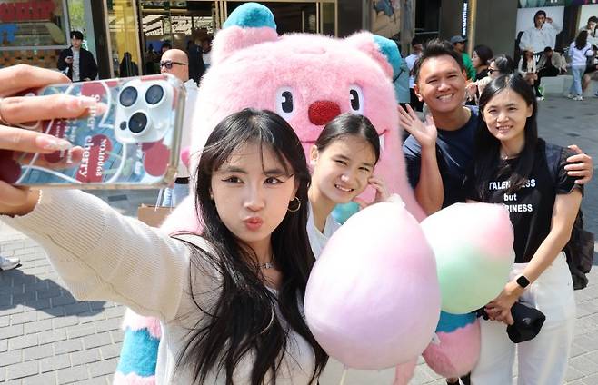 지난 4월 25일 오후 서울 중구 명동 밀리오레 앞에 마련된 '2025 서울환대주간, 서울여행정류소'에서 외국인 관광객들이 서울시 캐릭터인 해치와 기념촬영을 하고 있다. 뉴시스