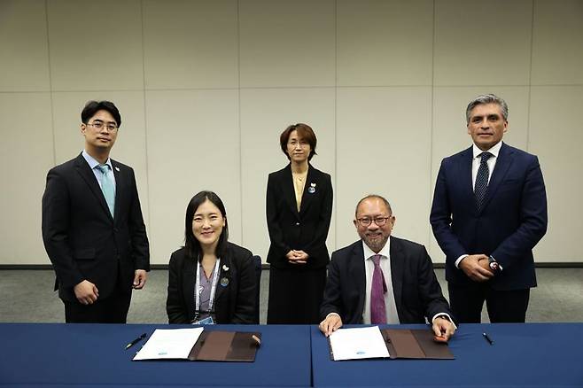 윤성미 APEC 고위관리회의(SOM) 의장(가운데)이 지켜보는 가운데 이지윤 APEC 고위관리(SOM)와 에두아르도 페드로사 APEC 사무국장이 청년을 위한 APEC기금  관련 서명식을 11일 갖고 있다. 외교부 제공