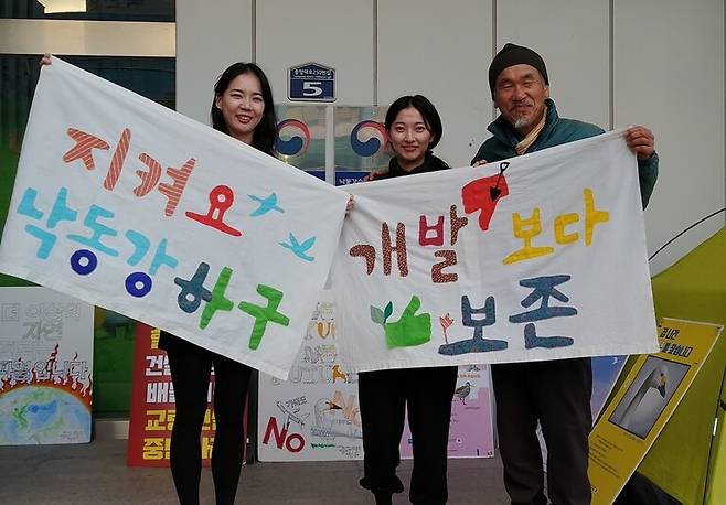 2024년 1월 경남 창원시 낙동강유역환경청 앞에서 노숙농성 중인 박중록 위원장(맨 오른쪽)이 농성장을 방문한 두 조카와 손팻말을 들고 있다. 농성은 2023년 1월27일부터 2024년 2월8일까지 진행됐다. 박중록 제공