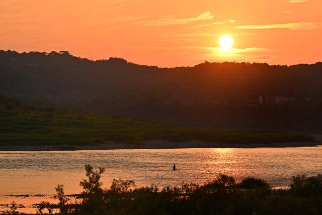 경기 연천 고랑포 여울 위로 석양이 내려앉자 강물은 비단처럼 빛났고. 그 위에 낚싯대를 드리운 낚시꾼의 실루엣은 서서히 지워지며 풍경 속 한 장면처럼 스며들었다.