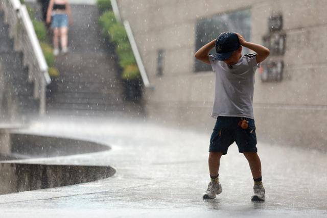 8일 서울 청계천에서 외국인 어린이가 비를 맞으며 춤을 추고 있다. 연합뉴스