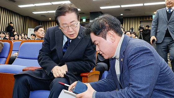 이재명 더불어민주당 대표가 지난 1월 15일 오전 서울 여의도 국회에서 열린 비상 의원총회에 참석해 윤종군 원내대변인과 대화하고 있다. 뉴스1