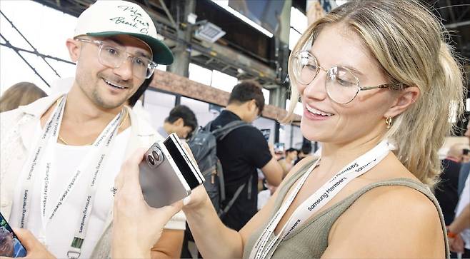 미국 뉴욕 브루클린 듀갈 그린하우스에서 열린 ‘갤럭시 언팩 2025’에서 관람객이 신제품 갤럭시 Z폴드7과 초박형 스마트폰인 갤럭시 S25 엣지의 두께를 비교해 보고 있다.  삼성전자 제공