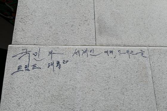 Graffiti mentioning U.S. President Donald Trump on the stone wall of Gwanghwamun Gate at Gyeongbok Palace in Jongno District, central Seoul [KOREA HERITAGE SERVICE]