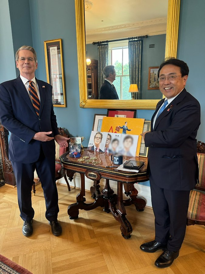 이달 초 미국을 방문한 아카자와 료세이 일본 경제재생상(오른쪽)이 미국 스콧 베선트 재무장관과 만나 기념촬영을 하고 있다. 가운데는 만화가 국회의원인 자민당의 아카마츠 켄 참의원이 그린 베선트 장관 초상회. [아카자와 료세이 X]