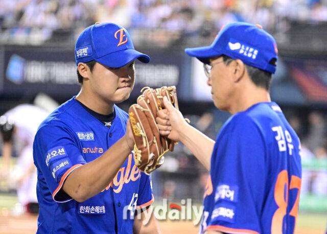 2025년 8월 9일 오후 서울 잠실구장에서 열린 '2025 신한 SOL뱅크 KBO 리그' 한화 이글스와 LG 트윈스의 경기. 한화 정우주가 7회말 1사 2.3루서 구원등판해 무실점으로 막은 뒤 코치의 축하를 받으며 더그아웃으로 들어가고 있다./마이데일리