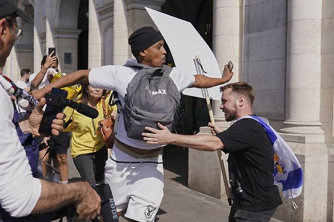 [런던=AP/뉴시스] 10일(현지 시간) 영국 런던에서 친팔레스타인 시위 참가자가 ‘이스라엘 인질 석방 촉구 행진’을 벌이는 친이스라엘 시위대 사이를 밀치며 지나가고 있다. 2025.08.11.