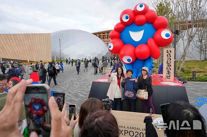 [오사카=AP/뉴시스] 오사카·간사이 엑스포 공식 개막일인 지난 4월 13일 박람회장을 찾은 방문객들이 공식 마스코트 '먀쿠먀쿠' 앞에서 기념 촬영을 하고 있다. 12일 개회식을 마친 이번 엑스포는 '생명이 빛나는 미래 사회의 디자인'을 주제로 오는 10월 13일까지 6개월간 열린다. 2025.04.13.