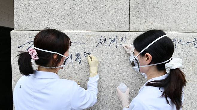 국립고궁박물관 전문가들이 낙서를 지우는 모습 (사진=국가유산청 제공, 연합뉴스)