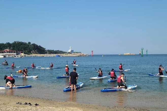 울산 동구가 피서철 일산해수욕장에서 운영하는 패들보드 체험 교실. 울산 동구 제공
