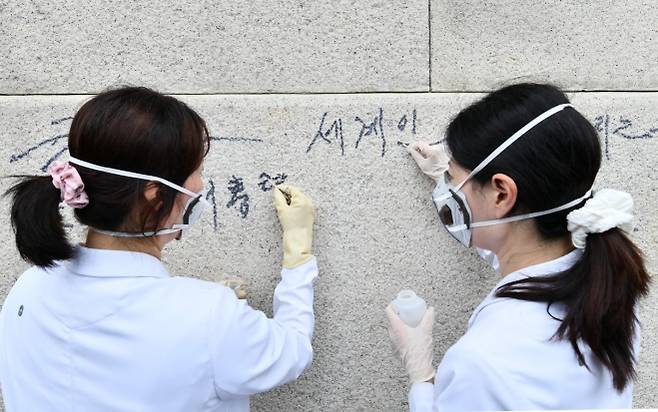 국립고궁박물관 유물과학과 관계자들이 11일 서울 경복궁 광화문 석축에 남은 낙서를 제거하고 있다. 국가유산청은 이날 오전 광화문 석축에 낙서를 한 79세 남성을 현장에서 확인해 경찰에 인계했다. 2025.8.11 국가유산청 제공