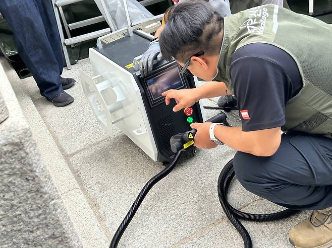 레이저 기기 작업 준비하는 관계자들      (서울=연합뉴스) 김예나 기자 = 11일 서울 경복궁 광화문 석축에 매직으로 쓴 낙서를 지우기 위해 문화유산 보존처리 업체 관계자들이 레이저 기기 작업을 준비하고 있다. 2025.8.11
    yes@yna.co.kr