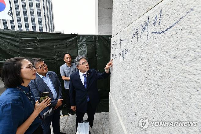낙서 제거 방법 논의하는 허민 국가유산청장 (서울=연합뉴스) 허민 국가유산청장(가운데)이 11일 서울 경복궁 광화문 석축에 남은 낙서를 살펴보며 제거 방법을 논의하고 있다.
    국가유산청은 이날 오전 광화문 석축에 낙서를 한 79세 남성을 현장에서 확인해 경찰에 인계했다.
    왼쪽부터 국립고궁박물관 정소영 유물과학과장, 국가유산청 이재필 국능유적본부장, 허민 국가유산청장. 2025.8.11 [국가유산청 제공. 재판매 및 DB 금지] photo@yna.co.kr