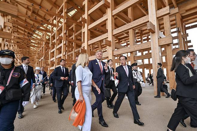 2025년 5월 21일, 일본 오사카에서 열린 2025 오사카 엑스포에서 네덜란드 국왕 빌럼알렉산더(가운데)가 네덜란드 국가의 날 기념 행사 참석을 위해 관계자들과 함께 목재 구조물인 ‘대지붕 링(Grand Ring)’ 아래를 걷고 있다.(사진=AFP)