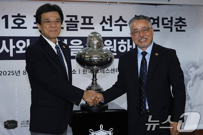 김원섭 KPGA 회장(오른쪽)과 야마나카 히로시 일본골프협회(JGA) 최고 운영 책임자가 12일 오전 서울 중구 태평로 한국프레스센터 서울클럽홀에서 열린 대한민국 1호 프로골프 선수 고 연덕춘 고문 일본오픈 트로피 복원 기념식에서 공개된 트로피 앞에서 손을 맞잡고 있다. 2025.8.12/뉴스1 ⓒ News1 박정호 기자
