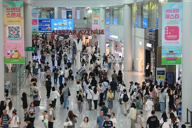 지난달 29일 인천국제공항 제1여객터미널 면세 구역이 여름휴가철을 맞아 해외로 나가려는 승객들로 붐비고 있다. 올 상반기 인천공항 이용객은 역대 최대를 찍으며 코로나 이전 수준을 넘어섰지만, 관광객들의 면세 쇼핑 수요가 급감해 면세점 운영 기업들은 실적 회복에 어려움을 겪고 있다. /연합뉴스