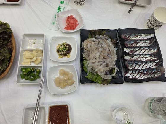 강원 속초 오징어 난전에서 두 마리를 5만6000원에 구매한 뒤 인근 횟집에서 구매한 2만원짜리 오징어 두 마리와 서비스 회. 사진 속초시청 홈페이지 캡처