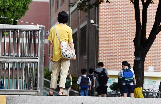 지난해 8월 서울 송파구의 한 초등학교 앞에서 학부모가 아이들의 등교하는 모습을 지켜보고 있다. 쿠키뉴스 자료사진