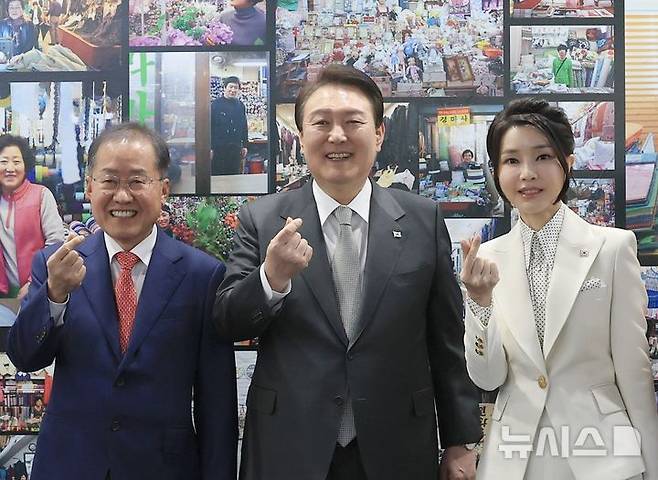 [대구=뉴시스] 윤석열 당시 대통령과 부인 김건희 여사가 대구 서문시장 인근에서 열린 '서문시장 100주년 기념 특별사진전'을 찾아 홍준표 대구시장과 기념촬영하고 있다. (사진=대통령실 제공) 2023.04.01. photo@newsis.com