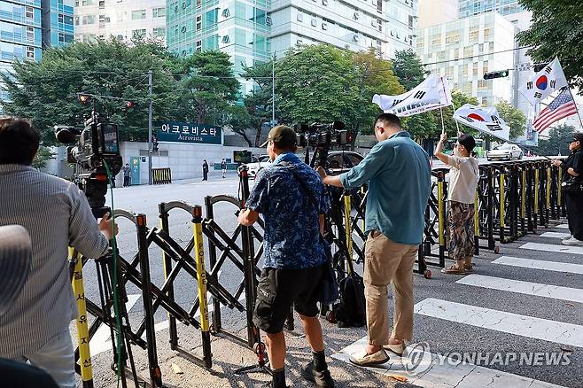 김건희 영장심사에 사저 앞에 모인 지지자들 (서울=연합뉴스) 신현우 기자 = 윤석열 전 대통령 배우자 김건희 여사에 대한 구속 전 피의자 심문(영장실질심사)이 열린 12일 서울 서초구 김 여사의 사저 건너편에 윤 전 대통령 부부 지지자가 태극기 등을 흔들고 있다. 2025.8.12 nowwego@yna.co.kr