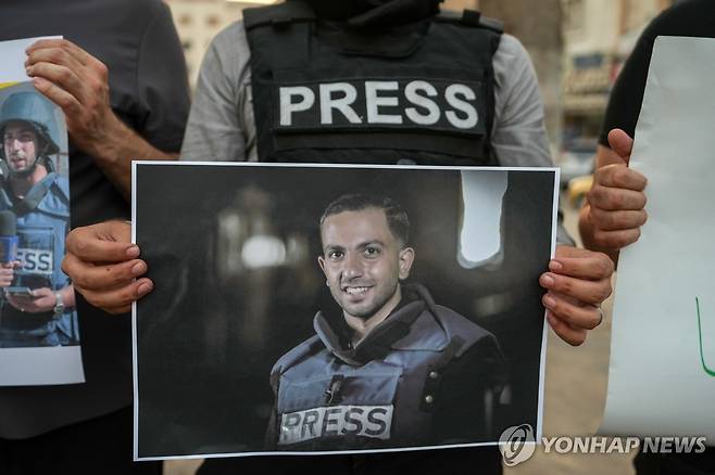 11일(현지시간) 한 시리아 언론인이 알샤리프 기자의 사진을 들고 있는 모습.  [EPA 연합뉴스. 재판매 및 DB 금지]