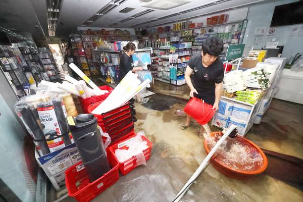 집중호우가 내린 13일 침수된 인천 서구 정서진 중앙시장 한 상가에서 상인이 배수 작업을 하고 있다. 2025.8.13 /연합뉴스