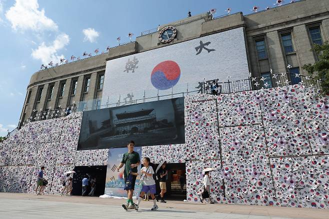다가오는 광복절, 서울광장 태극기 언덕광복 80주년을 앞둔 지난 10일 서울도서관 정문에 설치된 태극기 언덕 앞을 시민들이 지나고 있다. /연합뉴스