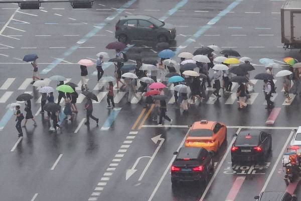비가 내린 13일 서울 세종대로 일대에서 차량 및 시민들이 이동하고 있다.연합
