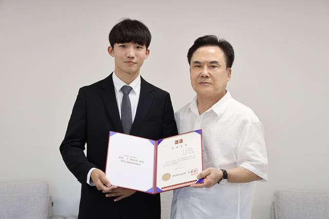 정현태 경일대 총장(왼쪽)이 경일대 철도학부 이강산(왼쪽) 학생에게 특별장학금을 수여하고 있다. 경일대 제공