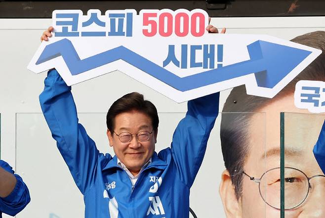 이재명 대통령이 대선 후보자였던 지난 5월 29일 서울 서초구 서울고속버스터미널광장에서 열린 유세에서 ‘코스피 5000 시대’ 팻말을 들고 경제회복 퍼포먼스를 하고 있다. (사진= 뉴시스)