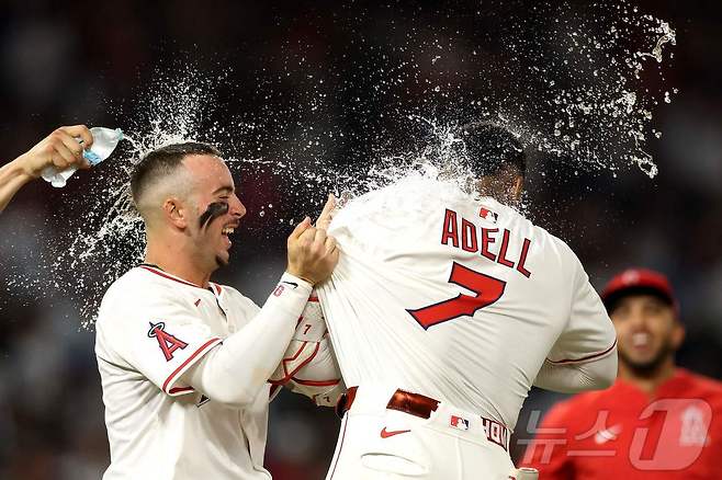 LA 에인절스의 조 아델이 13일(한국시간) 열린 LA 다저스전에서 연장 10회말 끝내기 안타를 때린 후 동료들의 축하를 받고 있다. ⓒ AFP=뉴스1