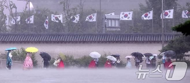 호우특보가 발효된 13일 서울 종로구 국립고궁박물관 인근에서 외국인 관광객들이 우산을 쓴 채 발걸음을 옮기고 있다. 2025.8.13/뉴스1 ⓒ News1 박지혜 기자