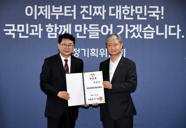 국정기획위원회 이한주 위원장(왼쪽)이 16일 서울 종로구 정부서울청사 창성동 별관에서 열린 출범식에서 사회1분과장을 맡은 이찬진 제일합동법률사무소 변호사에게 위촉장을 수여한 뒤 기념촬영을 하고 있다. 연합뉴스